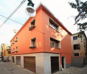 un bâtiment orange avec une lumière de rue devant lui dans l'établissement B&B Rialto Dream, à Venise