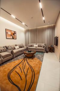 Una sala de estar con dos sofás y una mesa. en كنين للشقق الفندقية-Kanin Apartments, en Riad