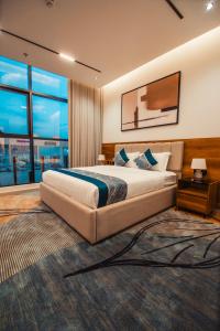 Un dormitorio con una cama grande y una ventana grande. en كنين للشقق الفندقية-Kanin Apartments, en Riad