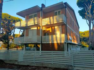 ein Haus mit einem weißen Zaun davor in der Unterkunft Il Villino Lido Spina - Monolocale 2 persone in Lido di Spina + 2 Fotos