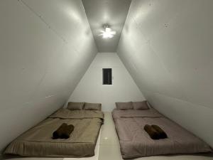 two beds in a white room with a ceiling at Bankhamkee Homestay in Chom Thong