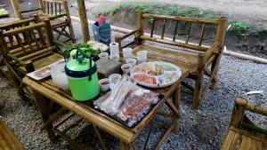 a wooden table with food on top of it at Bankhamkee Homestay in Chom Thong