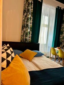 sypialnia z łóżkiem z kolorowymi poduszkami w obiekcie VINTAGE SENACKA APARTAMENTS w Krakowie