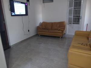 un soggiorno con divano e TV a schermo piatto di Casa Grande Barreiro Bh a Belo Horizonte
