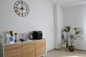 a living room with a clock on the wall at B&B Sole&Sale in San Leone