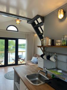 a kitchen with a sink and a living room at Kelluva Jokimaja in Turenki