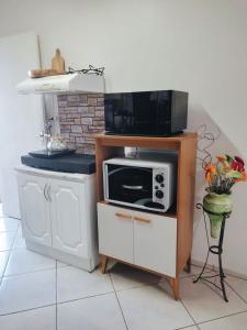 een magnetron op een standaard in een keuken bij Hospede-se aqui! Casa Inteira em Santa Clara do Sul in Santa Clara do Sul