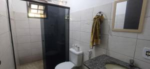 a bathroom with a toilet and a shower and a mirror at Casa para relaxar a 600 M da Praia do Paí Vitório in Búzios +6 photos