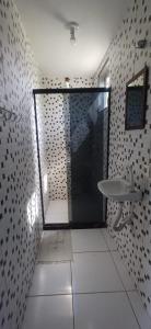 a bathroom with a shower with a sink and a toilet at Casa para relaxar a 600 M da Praia do Paí Vitório in Búzios