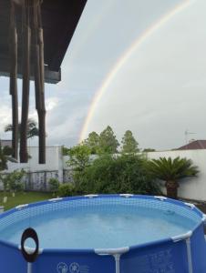 een regenboog in de lucht boven een zwembad bij Hospede-se aqui! Casa Inteira em Santa Clara do Sul in Santa Clara do Sul