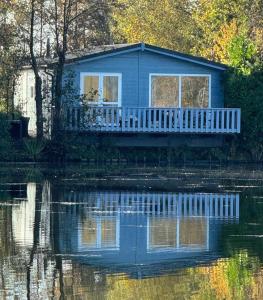 a blue house sitting on top of a body of water at Het sfeervolle Meerhuis voor een bijzonder verblijf in Oosterwolde