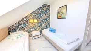 two beds in a room with a wall at Rezydencja Dwór Górny in Nowa Ruda