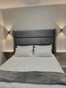 1 cama con cabecero negro y 2 almohadas blancas en The Urban Edge, en Ciudad del Cabo