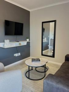 sala de estar con sofá, mesa y espejo en The Urban Edge, en Ciudad del Cabo 8 fotos más