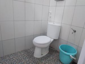 a bathroom with a toilet and a blue bucket at Bantul Syariah Homestay in Bantul