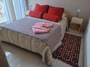 a bedroom with a bed with pink towels on it at Ty Bach in Puerto Madryn