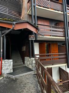 einen Eingang zu einem Gebäude mit einer Treppe und einem Zaun in der Unterkunft Apartemet montagne La pagne Motalbert au pied des pistes location semane de samadi a samedi in Montalbert