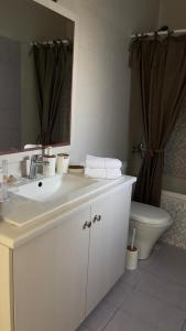 a bathroom with a sink and a toilet and a mirror at Latomi Sea View in Chios