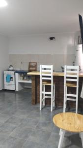 cocina con 2 sillas blancas y mesa de madera en Departamentos Mateo sin cochera, en San Pedro 6 fotos más