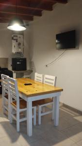 mesa de comedor con sillas blancas y TV en Departamentos Mateo sin cochera, en San Pedro