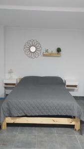 1 dormitorio con cama con colcha gris en Departamentos Mateo sin cochera, en San Pedro