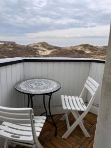 a table and two chairs sitting on a balcony at Studio Le Sandettie à 50m de la plage! in Fort-Mahon-Plage