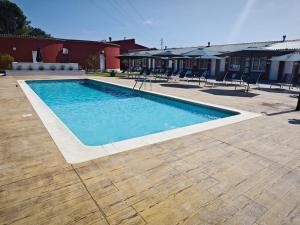 a swimming pool in a yard with chairs around it at Motel Caldas in Caldas de Reis