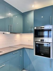 a blue kitchen with blue cabinets and appliances at Luxury town House with private garden in Duquesa in San Luis de Sabinillas