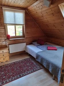 een slaapkamer met 2 bedden in een houten hut bij Guest house Zvejnieksēta in Pāvilosta