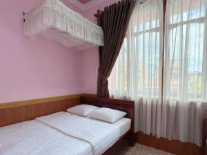 two twin beds in a room with a window at Nhat Quynh Hotel in Da Lat