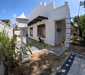 une maison blanche avec une maison ornithologique dans l'établissement Cinnamon Villa Weligama, à Weligama