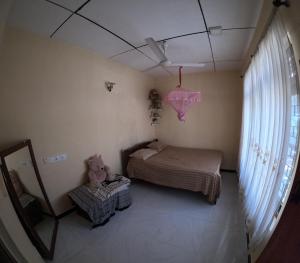 une petite chambre avec un lit et un miroir dans l'établissement Cinnamon Villa Weligama, à Weligama