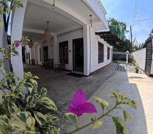 une terrasse d'une maison avec une fleur violette dans l'établissement Cinnamon Villa Weligama, à Weligama 5 autres photos