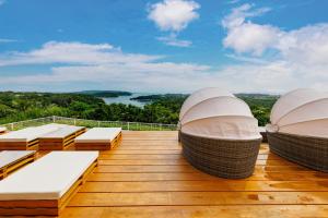 a deck with chaise lounges and a view of a lake at サウナでととのうpono 118は古宇利島から車で10分でお庭付き一棟貸 in Nago