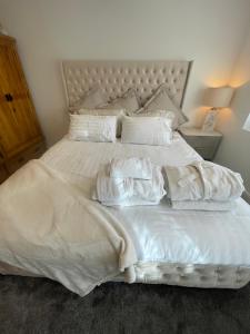 un lit blanc avec des serviettes dessus dans l'établissement Cwtch Mawr, à Cardiff
