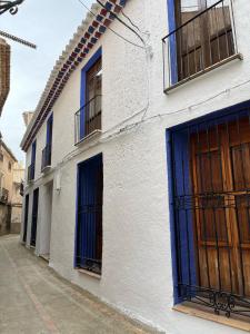 a white building with blue doors on a street at Casa rural Almazara in Letur