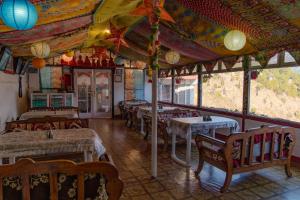 a restaurant with tables and chairs in a room at Hotel Victoriya Palace,Mcleod Ganj in McLeod Ganj