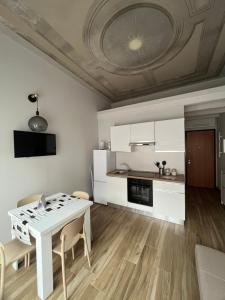 eine Küche und ein Esszimmer mit einem weißen Tisch und Stühlen in der Unterkunft Maison Cily in Asola