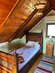 a bedroom with a bed and a wooden ceiling at Pansion Sašin Salaš 40m2 in Rumenka