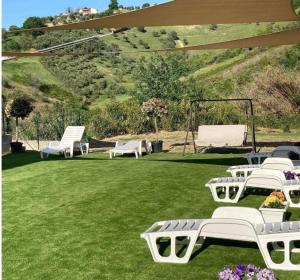 a group of white lounge chairs on a lawn at Casa dello Yoga Suite e Private Spa in Colonnella