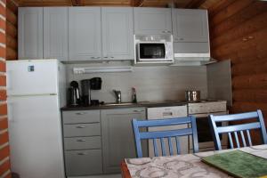 a kitchen with white cabinets and a white refrigerator at Markkula in Koitila