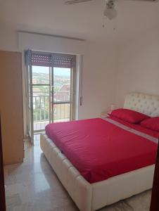 a bedroom with a large bed with a red blanket at Il rifugio di Diana in Falerna Marina