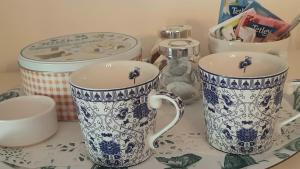 two blue and white cups sitting on a table at 2 Mill Cottages in Cornworthy