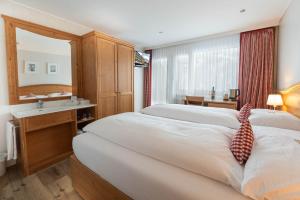 Ένα ή περισσότερα κρεβάτια σε δωμάτιο στο Hotel Bernerhof Grindelwald