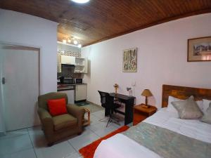 a bedroom with a bed and a desk and a chair at Millenium Manor Executive Homes in Centurion