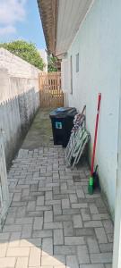 eine Terrasse mit einem Mülleimer und zwei Wischmopp in der Unterkunft Aluguel casa azul in Capão da Canoa