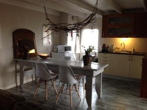 a kitchen with a wooden table and chairs and a kitchen with a tableablish at Gasthuys Hongerdyck in Bruchterveld