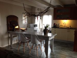 eine Küche mit einem Holztisch und Stühlen sowie eine Küche mit einem Tisch und Stühlen in der Unterkunft Gasthuys Hongerdyck in Bruchterveld