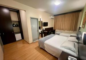 a hotel room with a large bed and a desk at Dom Pedro I Palace Hotel in Foz do Iguaçu
