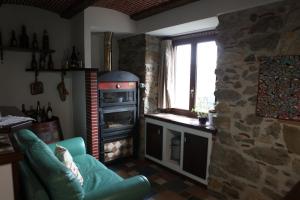 a living room with a stone stove and a couch at Al Cantello in Galati Mamertino